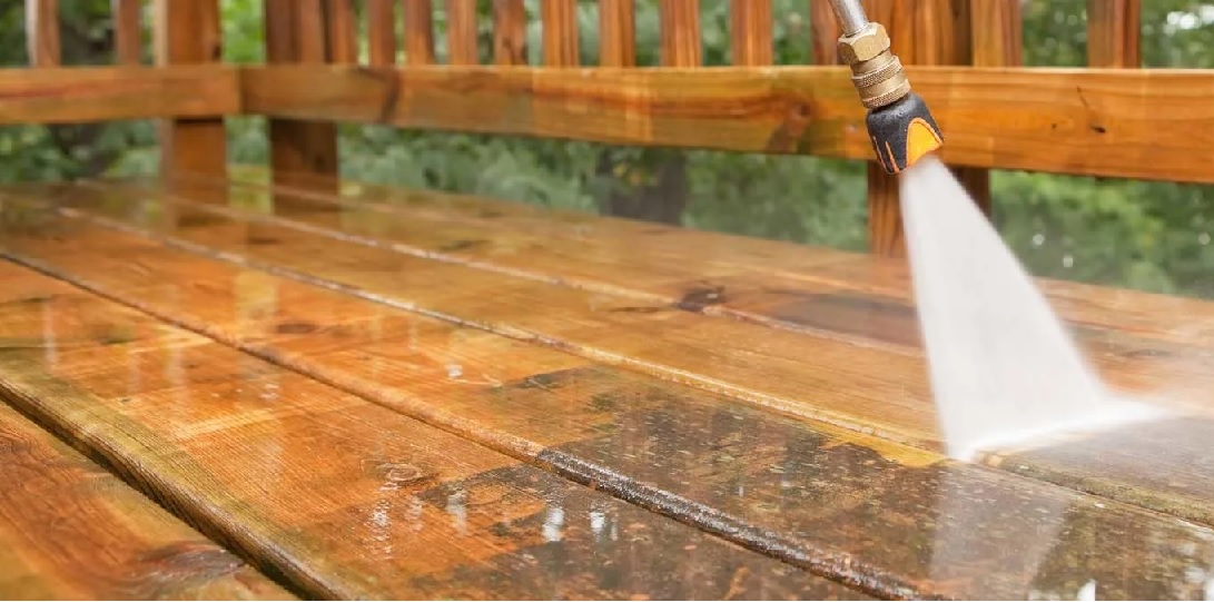 Pressure washing a wooden deck back to clean, bright wood